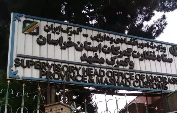 تصویری از تابلوی ستاد نظارت گمرکات استان خراسان و گمرک مشهد که در ورودی این مجموعه نصب شده است. نوشته‌های فارسی و انگلیسی روی تابلو، نام و حوزه فعالیت این مرکز گمرکی را نشان می‌دهند.