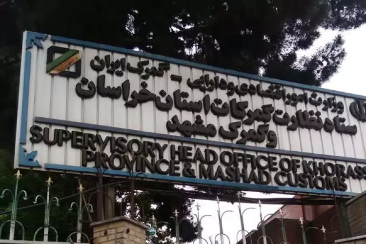 تصویری از تابلوی ستاد نظارت گمرکات استان خراسان و گمرک مشهد که در ورودی این مجموعه نصب شده است. نوشته‌های فارسی و انگلیسی روی تابلو، نام و حوزه فعالیت این مرکز گمرکی را نشان می‌دهند.