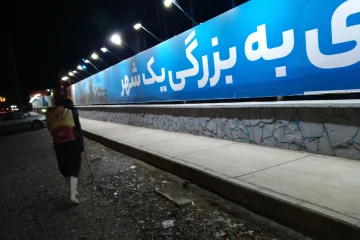 کارگر مجهز به سم‌پاش پشتی در حال اجرای عملیات ضدعفونی و سم‌پاشی در محوطه ایستگاه راه‌آهن در شب، جهت کنترل آفات و بهبود بهداشت محیط.